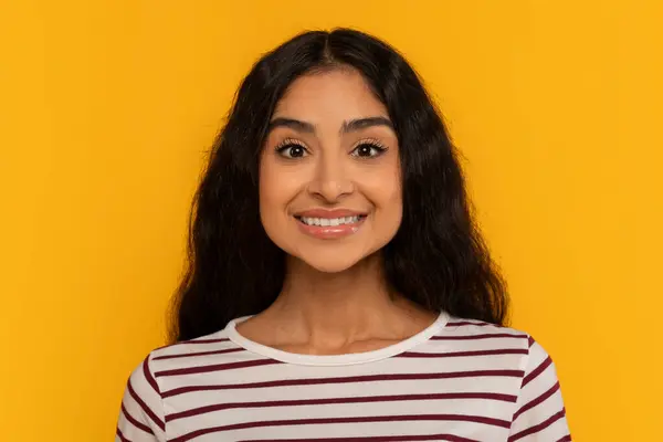 Çizgili Tişörtlü Genç Bir Kadın Parlak Sarı Bir Arka Plana — Stok fotoğraf