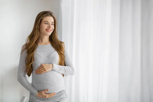 Ung Gravid Kvinna Kontemplativ Pose Tittar Genom Fönstret Med Optimism — Stockfoto