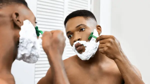 African American Man Carefully Shaving His Face Razor While Looking — Stock Photo, Image