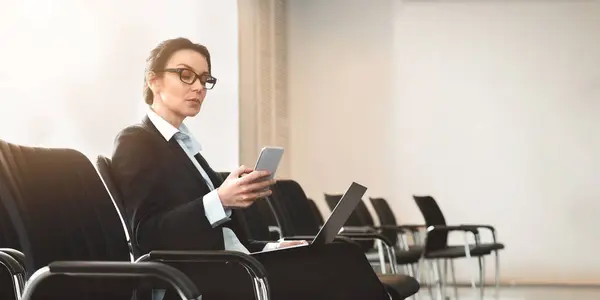 Elegant Businesswoman Uses Her Smartphone Laptop Simultaneously Empty Conference Room — Stock Photo, Image