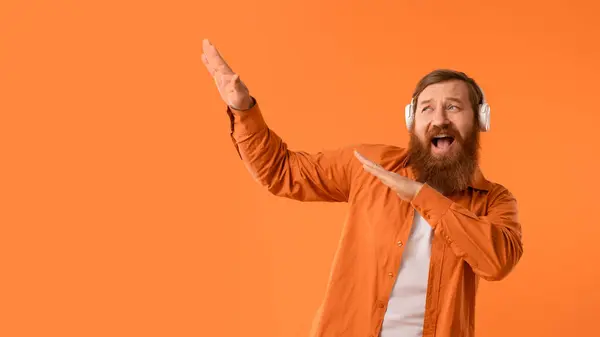 Ευτυχισμένος Κοκκινομάλλης Γενειοφόρος Άντρας Φωτεινό Πουκάμισο Και Ασύρματα Ακουστικά Ακούγοντας — Φωτογραφία Αρχείου