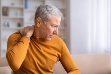 An older male individual experiencing discomfort in his shoulder, possibly indicative of a common age-related condition clipart