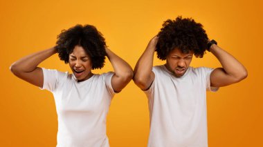 Binlerce yıllık Afro-Amerikan erkek ve kadın beyaz t-shirtler giyip kafalarına dokunup suratlarını buruşturuyorlar. Siyahi çift zor zamanlar geçiriyor, zor zamanlar geçiriyor, sarı arka plan