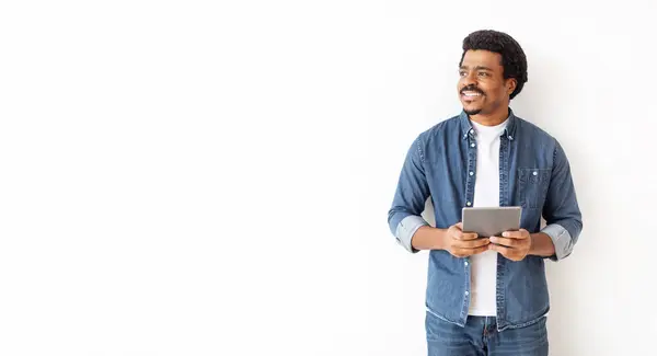 Relajado Hombre Negro Traje Mezclilla Sosteniendo Tableta Digital Mirando Lado —  Fotos de Stock