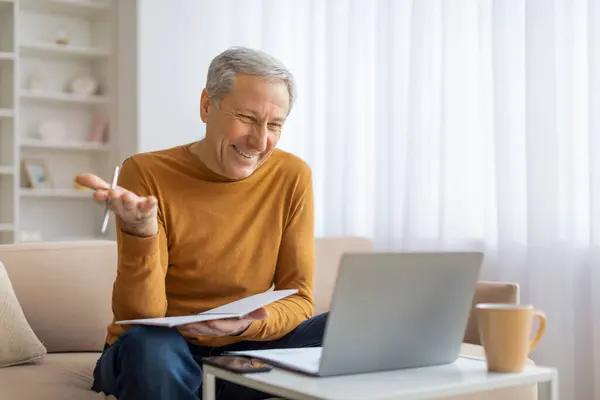 Elder Gentleman Gesturing While Explaining Point Video Call Papers Laptop — Stock Photo, Image