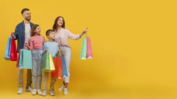 Eğlenceli Aile Babaları Çocuklar Alışveriş Torbalarını Gösteriyor Sarıda Duruyor Fotokopi — Stok fotoğraf