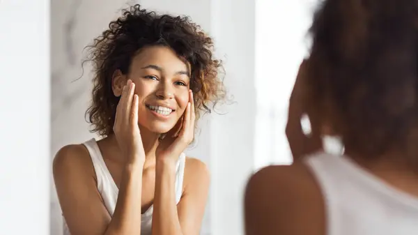 Glad Afro Flicka Röra Hennes Ansikte Stående Badrum Speglar Sig — Stockfoto