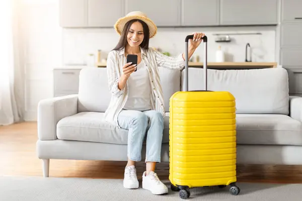 Cheerful Woman Straw Hat Checks Her Smartphone Yellow Suitcase Comfortable — Stock Photo, Image