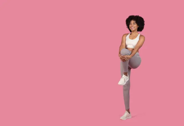 Fit Junge Afroamerikanerin Bei Einer Beinstreckung Vor Rosa Hintergrund Die — Stockfoto