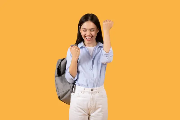 Joyful Young Woman Backpack Clenching Her Fist Celebratory Gesture Solid — Stock Photo, Image