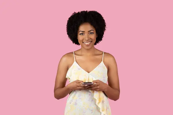 Usmívající Mladá Afroameričanka Pomocí Mobilu Sobě Letní Šaty Růžovém Pozadí — Stock fotografie