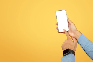 Akıllı telefonu sunan bir el boş, düzenlenebilir bir ekranla ve sıcak sarı bir arka planla maketler için.