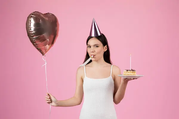 パーティーで笑顔の女性 ハートバルーンとバースデーケーキのスライス ピンクの背景にパーティーの準備 — ストック写真