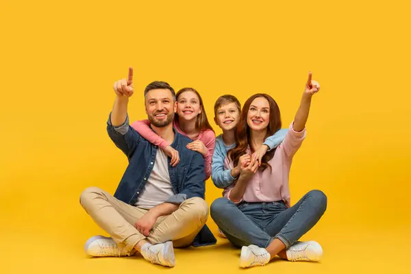 Cheerful European Family Four Two Kids Pointing Upwards While Sitting — Stock Photo, Image
