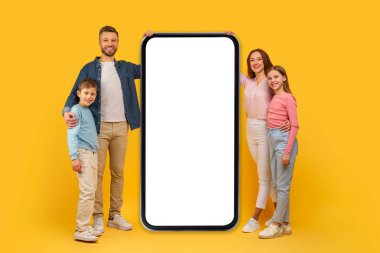 Happy family presenting big smartphone screen mockup copy space for mobile app advertisement, isolated on yellow clipart