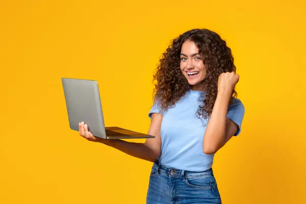 Dizüstü Bilgisayar Tutan Sarı Arka Planda Mutlu Bir Yumrukla Tezahürat — Stok fotoğraf