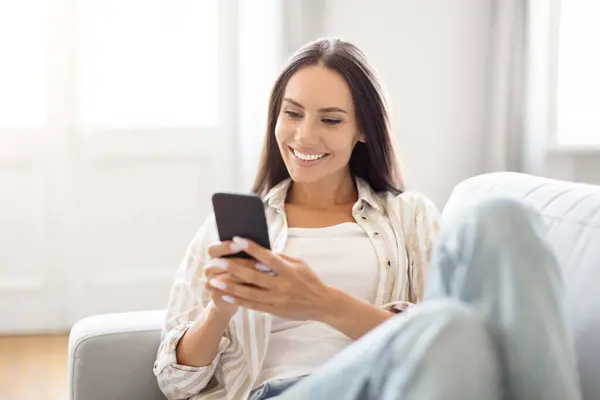 Woman Relaxes Couch Her Smartphone Embodying Moment Quiet Enjoyment Serene — Stock Photo, Image