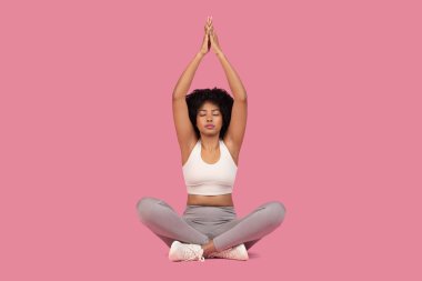 Serene African American woman demonstrating mindfulness and tranquility in a meditation pose clipart