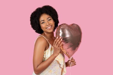 African American woman in a light summer dress hugging a heart-shaped balloon with a tender expression clipart