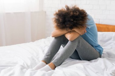 Afrikalı-Amerikalı kadın yatak, boş alanı oturan depresyon acı