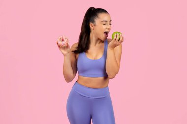 A fit woman in activewear faces the choice between a healthy apple and an unhealthy donut clipart