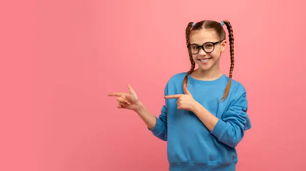 Smiling Young Girl Glasses Points Sideways Suggesting Choice Direction Pink — Stock Photo, Image