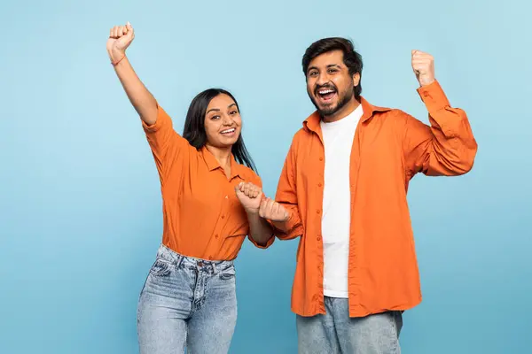 Energetic Indian Couple Raised Fists Celebrating Victory Success Matching Orange — Stock Photo, Image