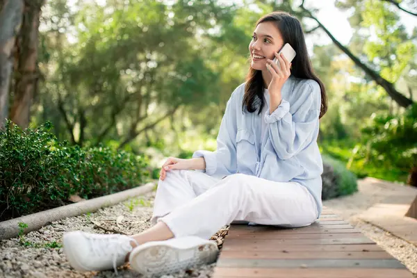 Μια Γυναίκα Απολαμβάνει Μια Ευχάριστη Τηλεφωνική Συνομιλία Στο Πάρκο Συνοψίζοντας — Φωτογραφία Αρχείου