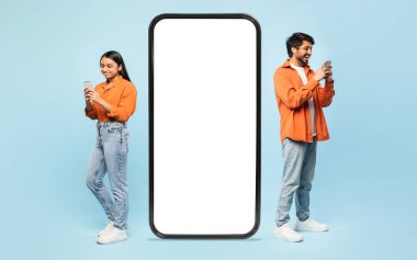 Gülümseyen Hintli çift büyük boyutlu akıllı telefon boş ekran ile etkileşime giriyor, uygulamaları veya web sitelerini göstermek için ideal
