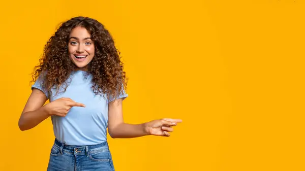 Surprised Woman Pointing Side Looking Something Interesting Yellow Backdrop Copy — Stock Photo, Image