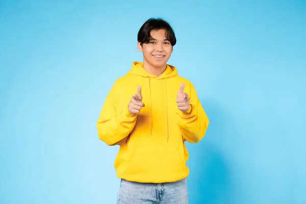 Jovem Asiático Feliz Capuz Amarelo Aponta Ambos Dedos Para Câmera — Fotografia de Stock