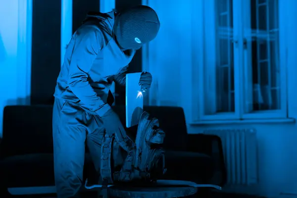 Cloaked Figure Organizes Tools Preparing Break Sinister Lamp Illumination Suggesting — Stock Photo, Image