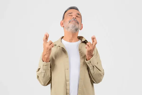 Elderly Man Stands Hopeful Expression Crossing His Fingers Wishing Good — Stock Photo, Image