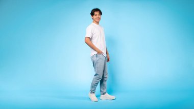 Sıradan giyinmiş, kendine güvenen, mavi bir geçmişi olan Asyalı genç bir adamın yan görüntüsü.