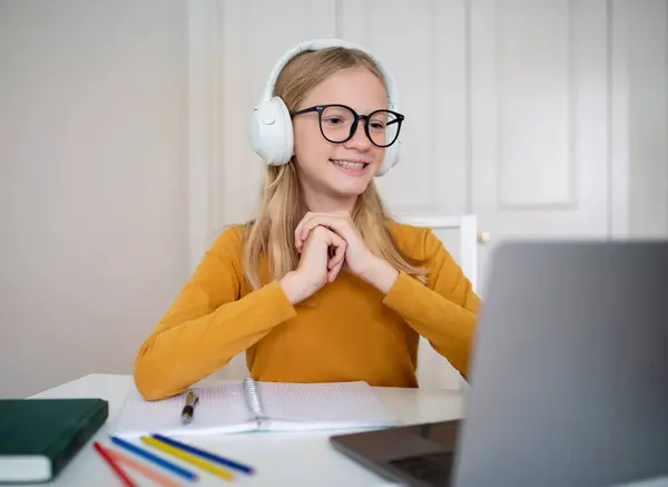 Szczęśliwa Młoda Studentka Okularach Słuchawkach Siedząca Przy Biurku Uczestnicząca Wirtualnej — Zdjęcie stockowe