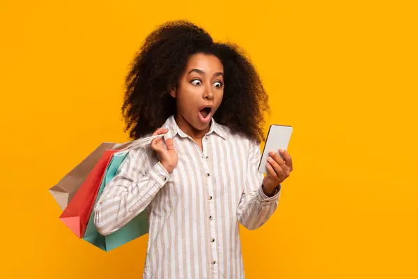 Amazed Afro Amerikaanse Vrouw Shopper Met Kleurrijke Tassen Smartphone Gele — Stockfoto