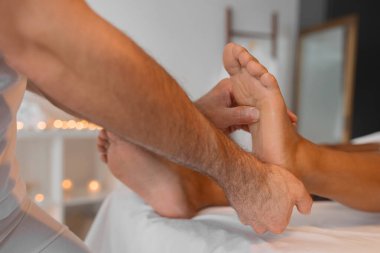 Becerikli eller müşterilerin ayakları üzerinde çalışır. Rahatlama ve rahatlama sağlar. Yumuşak odaklı arka planı olan sıcak bir kaplıca atmosferinde yakalanır.