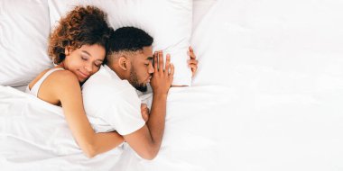 Ortak uyku. Onunla birlikte uyumak yatak, üstten görünüm erkek arkadaşlarını geri, kucaklayan mutlu Afrikalı-Amerikalı kadın