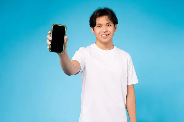 年轻的亚洲人推出了一款屏幕空白的智能手机 很适合模仿或应用演示 酷毙了 — 图库照片