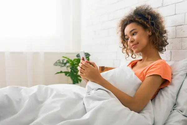 Young African American Woman Lies Comfortably Bed Engaged Her Smartphone — Stock Photo, Image