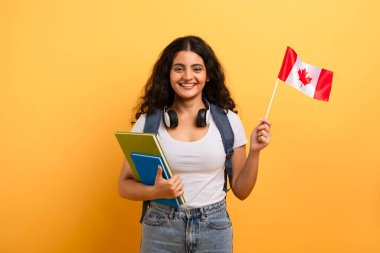 Cheerful young learner displaying a Canadian flag, representing pride and cultural identity clipart