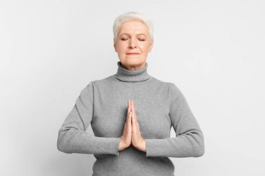 The elderly European woman is in meditation pose, evoking a sense of spirituality and introspection indicative of s3niorlife reflection clipart
