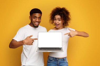 Büyük web sitesi. Boş dizüstü ekran, turuncu stüdyo arka plan, boş alan işaret Pozitif Afrikalı çift
