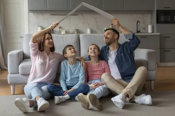 Família Sorridente Sentado Chão Faz Uma Forma Casa Com Cartão — Fotografia de Stock