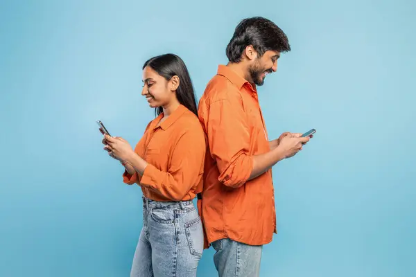 Молодой Индиец Женщина Стоят Спиной Спине Поглощенные Своими Мобильниками Синем — стоковое фото