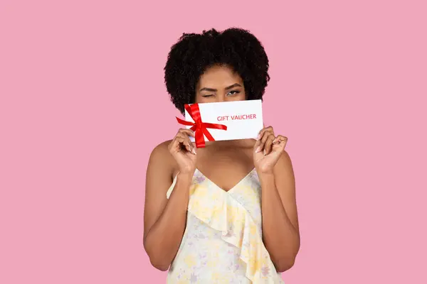 African American Woman Floral Dress Showcases Her Presenting Gift Voucher — Stock Photo, Image