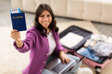 Young traveler holding a passport with a suitcase, indicating readiness for an upcoming trip, home interior clipart
