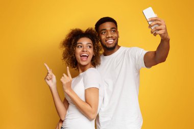 Neşeli Afro-Amerikan erkek ve kadın selfie smartphone, turuncu arka plan, yapım alanı Kopyala
