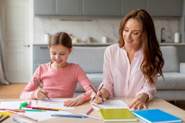 Bir Avrupa aile anı bir anne ve kızı arasındaki sevgi ve sevgiyi yakalıyor evde yaratıcı bir aktivite sırasında.