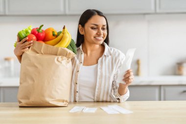 Hintli bir kadın mutfağında gülümsüyor, yeni bakkaliye ve bütçe işlerini zarafet ve kolaylıkla hallederken bin yıllık zekasıyla güçleniyor.